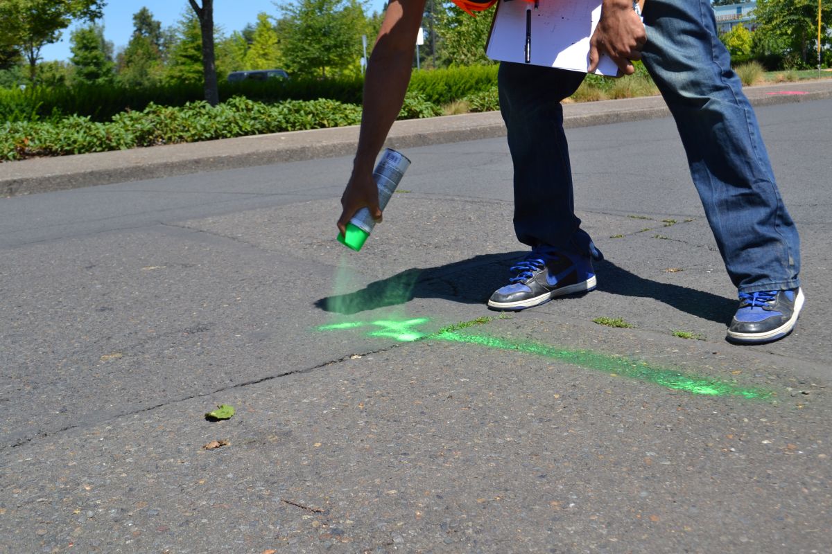City of McMinnville Intern sprays markings on a road for his internship project