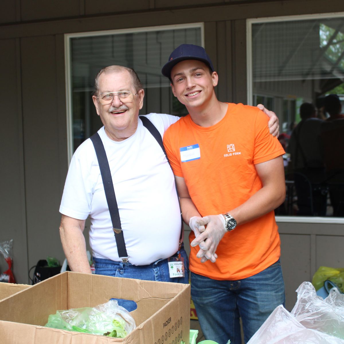 Marckus Smith, intern at Solid Form, stands with another volunteer at Harvest2Home