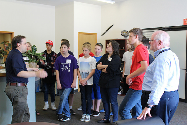 Middle school students and McMinnville Mayor Scott Hill, listen as Jeff Ratcliffe, Chief Technical Officer, tells students about the company.