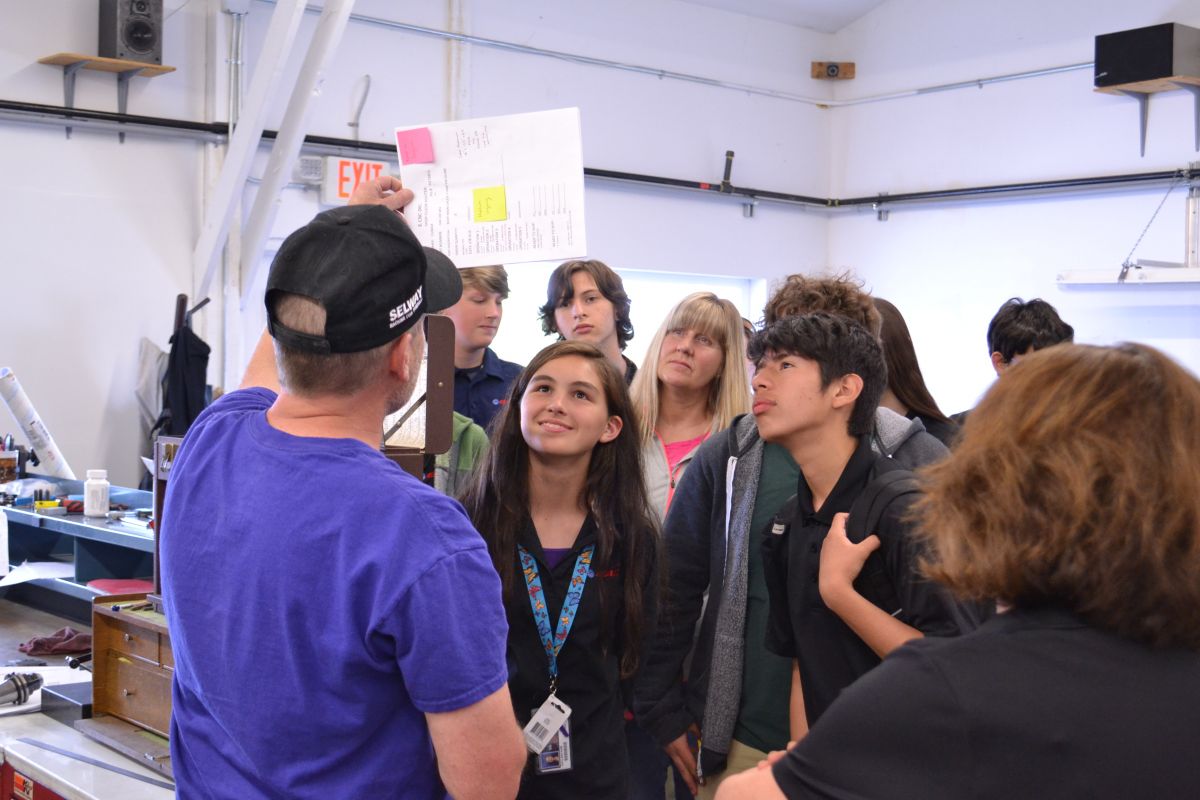 McMinnville High School students view plans for a piece being manufactured in the CNC machines